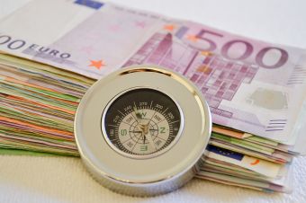 Foto: Geldscheine mit eine Kompass davor